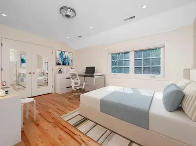 a white bedroom with a bed and a desk at Green Utopia in Wilton