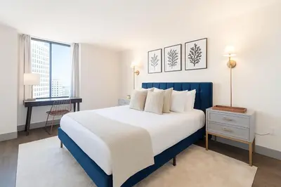 a bedroom with a blue and white bed and a desk at Convention Center 1BR Condo Downtown Hartford and GYM in Hartford