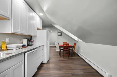 a kitchen with white cabinets and a table with chairs at Freshly Redone & Newly Furnished! A MUST SEE! in New Britain