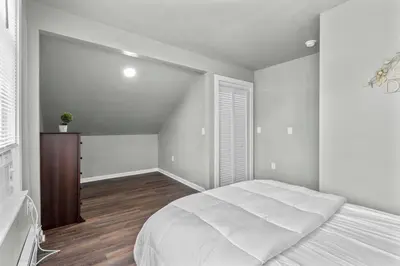 a bedroom with a large white bed and wooden floors at Freshly Redone & Newly Furnished! A MUST SEE! in New Britain