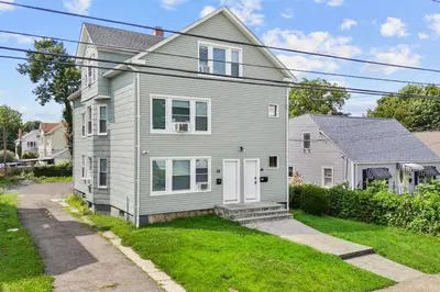 a gray house with white doors and a yard at Freshly Redone & Newly Furnished! A MUST SEE! in New Britain