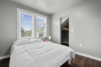 a white bedroom with a large bed and two windows at Freshly Redone & Newly Furnished! A MUST SEE! in New Britain