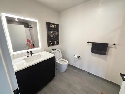 a bathroom with a sink and a toilet and a mirror at The Westchester Experience in White Plains