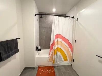 a bathroom with a shower curtain and a tub at The Westchester Experience in White Plains