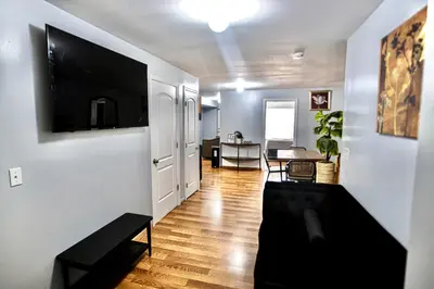 a living room with a flat screen tv on a wall at Lovely Loft in Newark Minutes from NYC, EWR & American Dream Mall in Newark