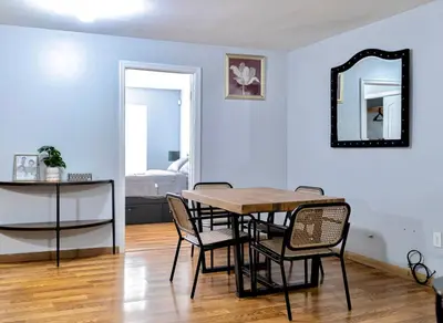 a dining room with a table and chairs and a mirror at Lovely Loft in Newark Minutes from NYC, EWR & American Dream Mall in Newark