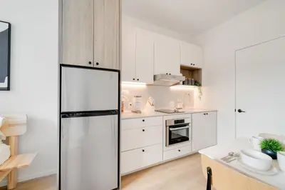 a kitchen with white cabinets and a refrigerator at One Grove in Jersey City in Jersey City