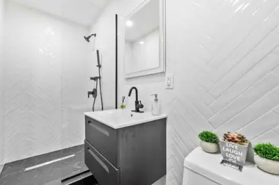 a bathroom with a sink and a toilet and a mirror at Luxe Studio with Charming Juliet Balcony in New York