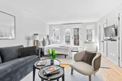 a living room with a couch and a table at Luxe Studio with Charming Juliet Balcony in New York