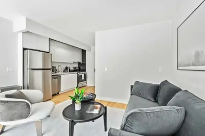 a living room with a couch and chairs and a table at Luxe Studio with Charming Juliet Balcony in New York