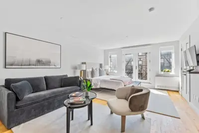 a living room with a couch and a bed at Luxe Studio with Charming Juliet Balcony in New York