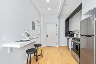 a kitchen with a counter and two stools in it at Studio w Charming Juliet Balcony in Upper East in New York