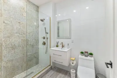 a bathroom with a shower and a toilet and a sink at Studio w Charming Juliet Balcony in Upper East in New York