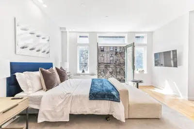 a bedroom with a large bed and a couch at Studio w Charming Juliet Balcony in Upper East in New York