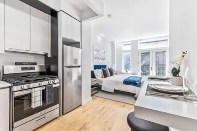 a kitchen with a stove and a bed in a room at Studio w Charming Juliet Balcony in Upper East in New York