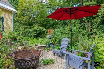 a red umbrella and a blue bench with a basket at Vermont Lake Whitingham Mount Snow Area Apartment in Jacksonville