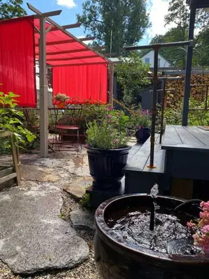 a garden with a fountain and a red shed at Vermont Lake Whitingham Mount Snow Area Apartment in Jacksonville