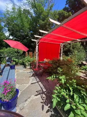 a red shed with a table and a red umbrella at Vermont Lake Whitingham Mount Snow Area Apartment in Jacksonville