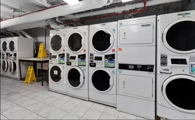 a row of washing machines in a laundry room at 73-308 New 1BR 1Bth UWS Doorman Gym in New York