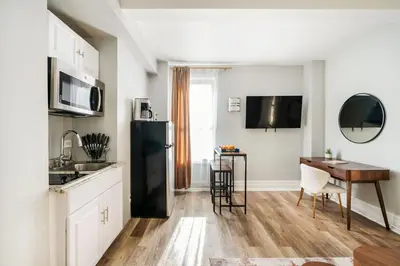 a kitchen with a black refrigerator and a table at 73-608 New 1BR 1Bth UWS Doorman Gym in New York
