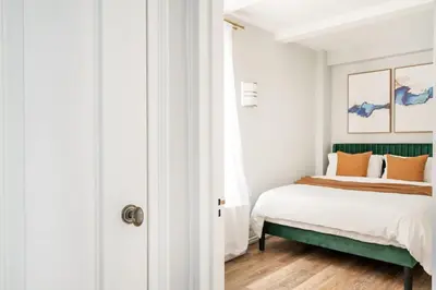 a bedroom with a bed with a green headboard at 73-608 New 1BR 1Bth UWS Doorman Gym in New York
