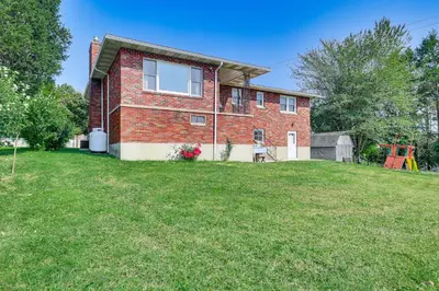 a red brick house with a large yard at Watertown Home with Yard 1 Mi to Echo Lake Park! in Watertown