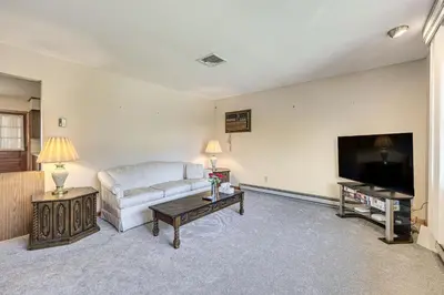 a living room with a couch and a flat screen tv at Watertown Home with Yard 1 Mi to Echo Lake Park! in Watertown