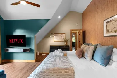 a bedroom with a large white bed and a tv at Luxury Chalet, Firepit, Sauna, Pet Friendly, 5 mins to Windham Mtn resort in Windham