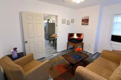 a living room with two chairs and a fireplace at Hidden Gem-1Bedroom with Plenty Free Street Parking in Communipaw