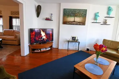 a living room with a television and a table at Lovely Victorian Home with Bed and Breakfast Energy in West Bergen