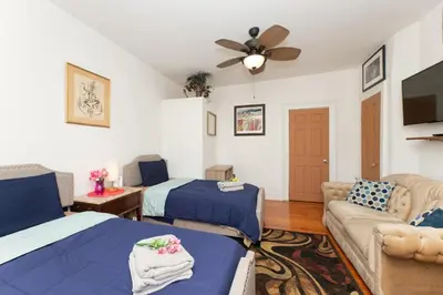a living room with two beds and a couch at 3 Bedroom Gem! King, Full & Twin Beds, Sauna with Free Parking plus more in Jersey City