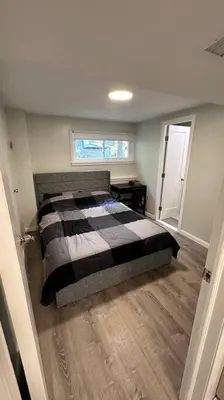 a bedroom with a bed with a black and white blanket at 2 Bd 2 Ba Unit laundry &kitchen in Great Neck