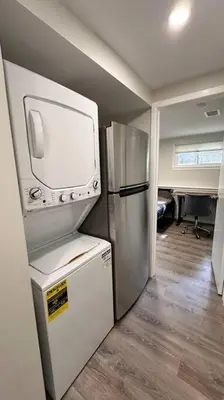 a small kitchen with a tv and a refrigerator at 2 Bd 2 Ba Unit laundry &kitchen in Great Neck