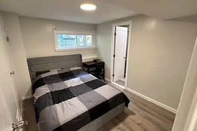 a bedroom with a bed with a black and white comforter at 2 Bd 2 Ba Unit laundry &kitchen in Great Neck
