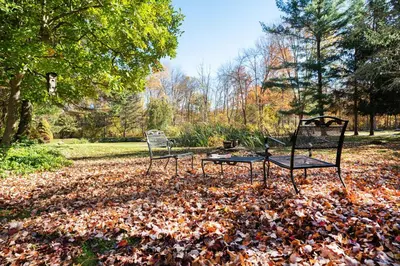 two chairs and a table in a pile of leaves at ABC Stay - Connecticut Five Bedroom Home in Warren