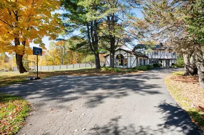 a road with trees and a house in the background at ABC Stay - Connecticut Five Bedroom Home in Warren