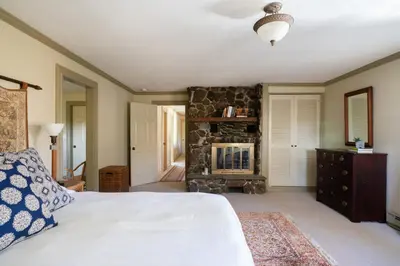 a bedroom with a bed and a stone fireplace at ABC Stay - Connecticut Five Bedroom Home in Warren