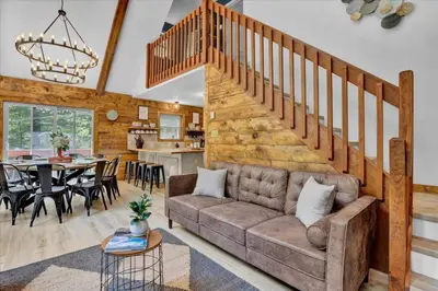 a living room with a couch and a dining room at Chalet Lake, Movie Theater, Hot Tub, Arcade in Gouldsboro
