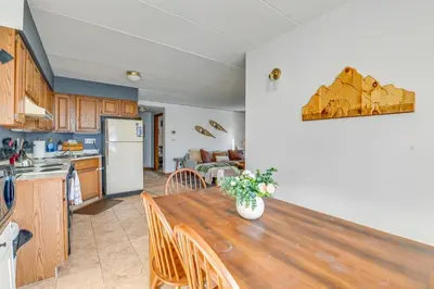 a kitchen and dining room with a wooden table at Bearfoot Apres Mtn-View Condo Less Than 1 Mi to Mt Snow! in Podunk