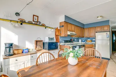 a kitchen with a wooden table with a vase of flowers on it at Bearfoot Apres Mtn-View Condo Less Than 1 Mi to Mt Snow! in Podunk