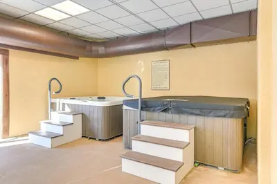 a room with a tub and stairs in it at Bearfoot Apres Mtn-View Condo Less Than 1 Mi to Mt Snow! in Podunk