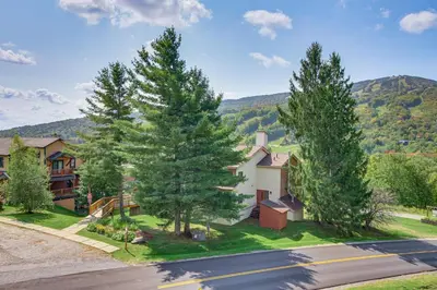 a house with trees on the side of a street at Bearfoot Apres Mtn-View Condo Less Than 1 Mi to Mt Snow! in Podunk