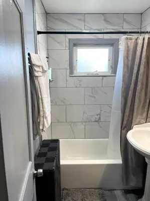 a bathroom with a white tub and a sink at New Quaint & Convenient Hideaway Great Location in East Hartford
