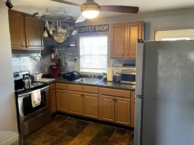 a kitchen with wooden cabinets and a stainless steel refrigerator at New Quaint & Convenient Hideaway Great Location in East Hartford