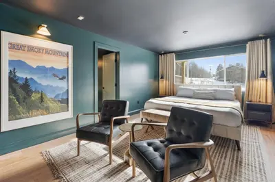 a bedroom with a bed and two chairs at Inn At Mount Snow in West Dover