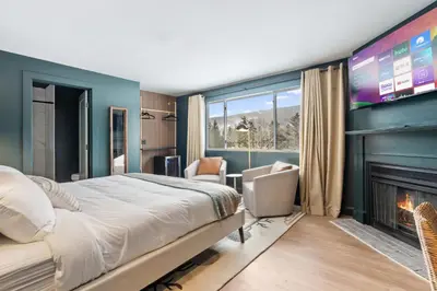 a bedroom with a large bed and a fireplace at Inn At Mount Snow in West Dover
