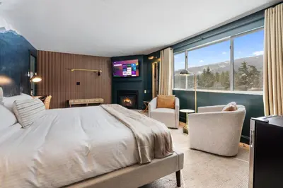 a bedroom with a bed and a tv and a fireplace at Inn At Mount Snow in West Dover