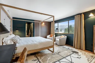 a bedroom with a large bed and a desk and chair at Inn At Mount Snow in West Dover