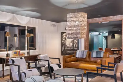 a living room with a couch and tables and chairs at Inn At Mount Snow in West Dover