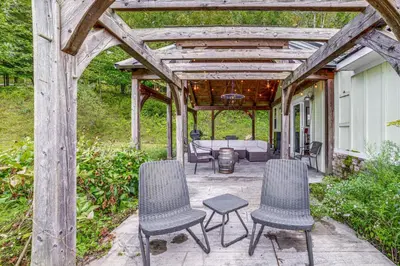 a pergola with two chairs and a table on a patio at Home with Private Dock Near Colgate University in Hamilton